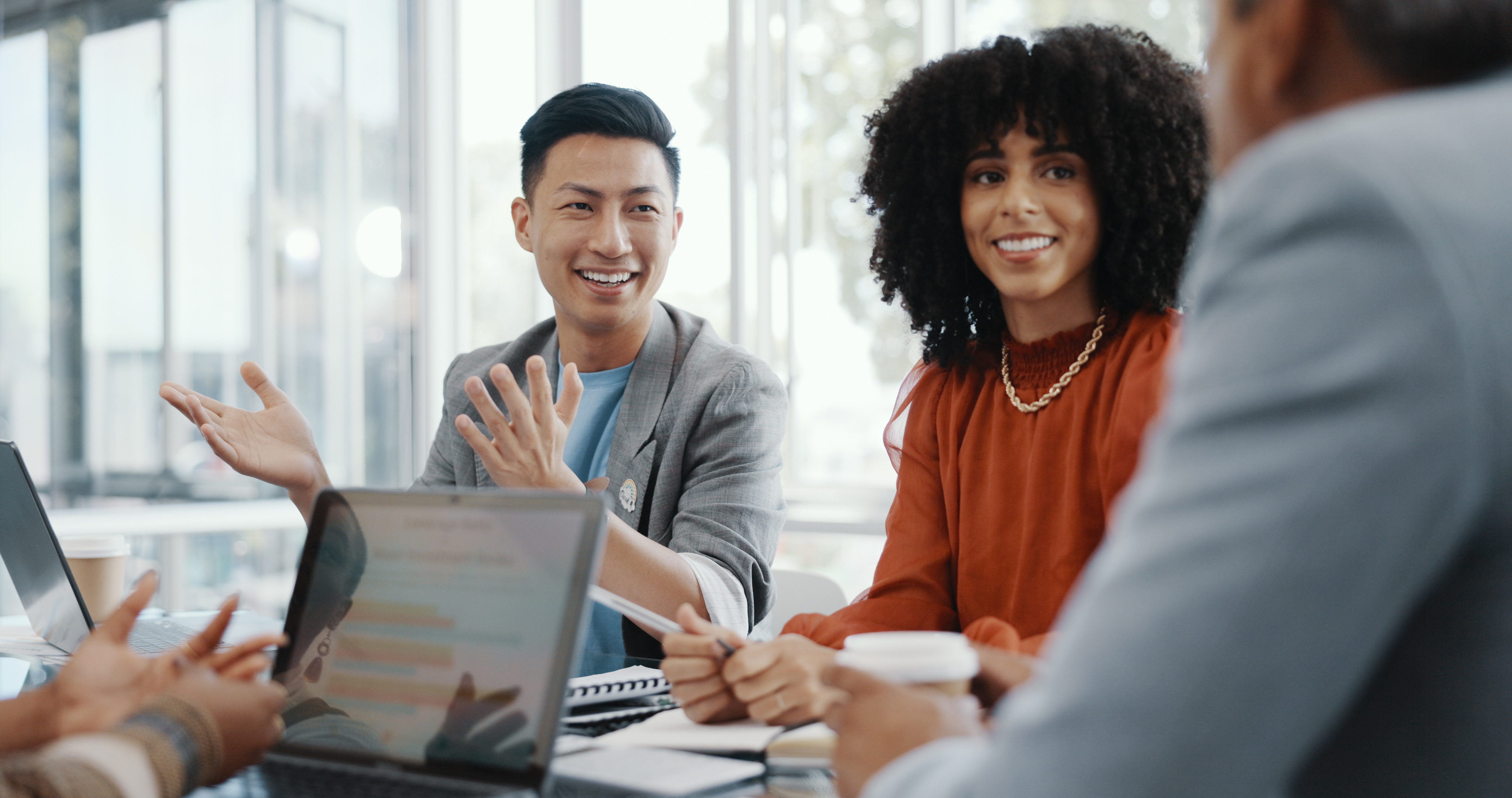 diverse-colleagues-smiling-and-discussing-in-office-meeting.jpeg