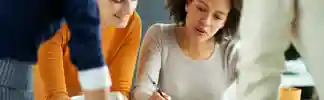 diverse-women-collaborating-over-notebook-and-tablet.jpeg